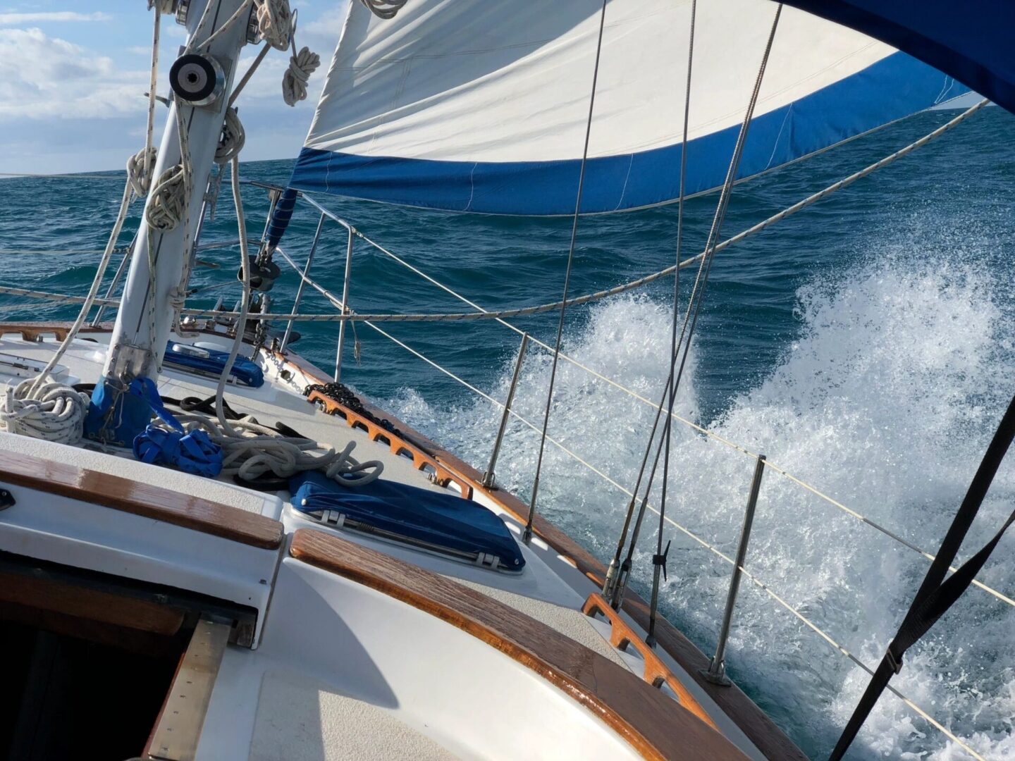 A boat is sailing in the ocean with waves crashing behind it.