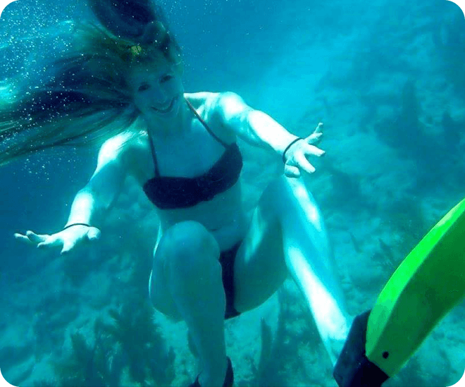 A woman in black bikini swimming under the water.